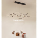 DRAPMODE modern wave-shaped LED pendant light in sand black finish, hanging over a contemporary living room set