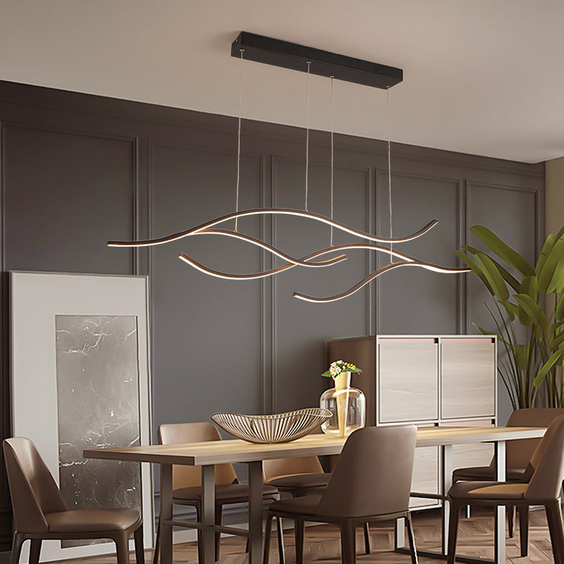 DRAPMODE modern wave-shaped LED pendant light with a sleek black finish hanging over a contemporary dining table