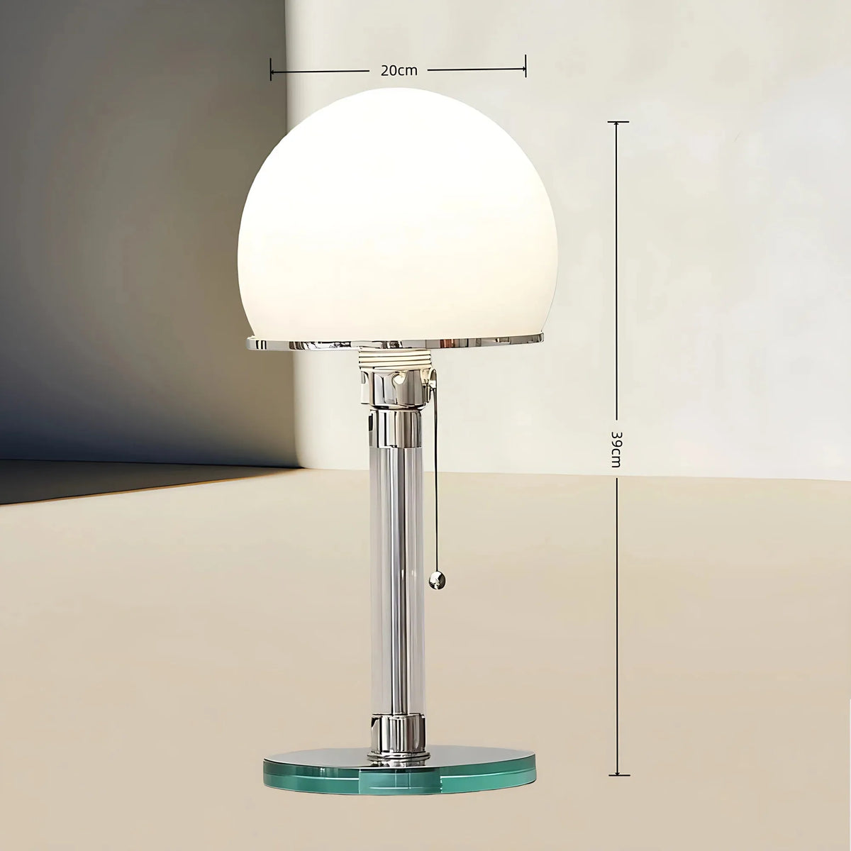 A modern table lamp with a glowing white spherical shade, a polished chrome stem, and a round clear glass base, shown with dimension lines indicating 20 cm width and 36 cm height.